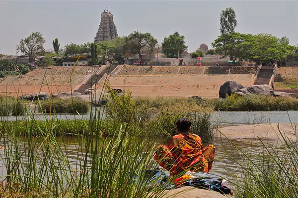 hampi river india, Indian woman washing clothes in the river